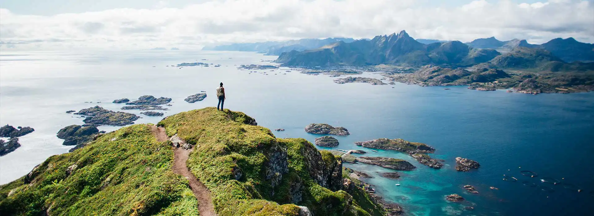 Hiking in Lofoten Islands, Norway, overlooking scenic fjords.